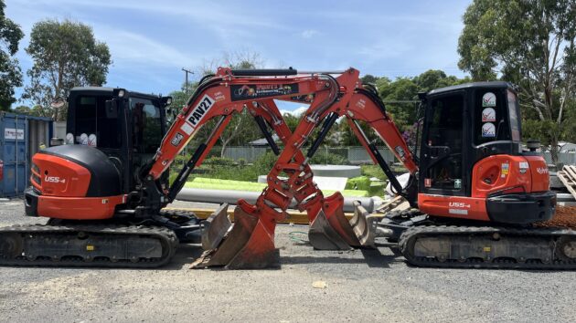 Excavators equipped with bucket attachment used in earthmoving operations.
