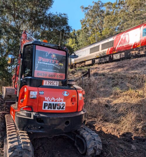 Pavitt Group civil construction team trenching with excavator on-site in Queensland.